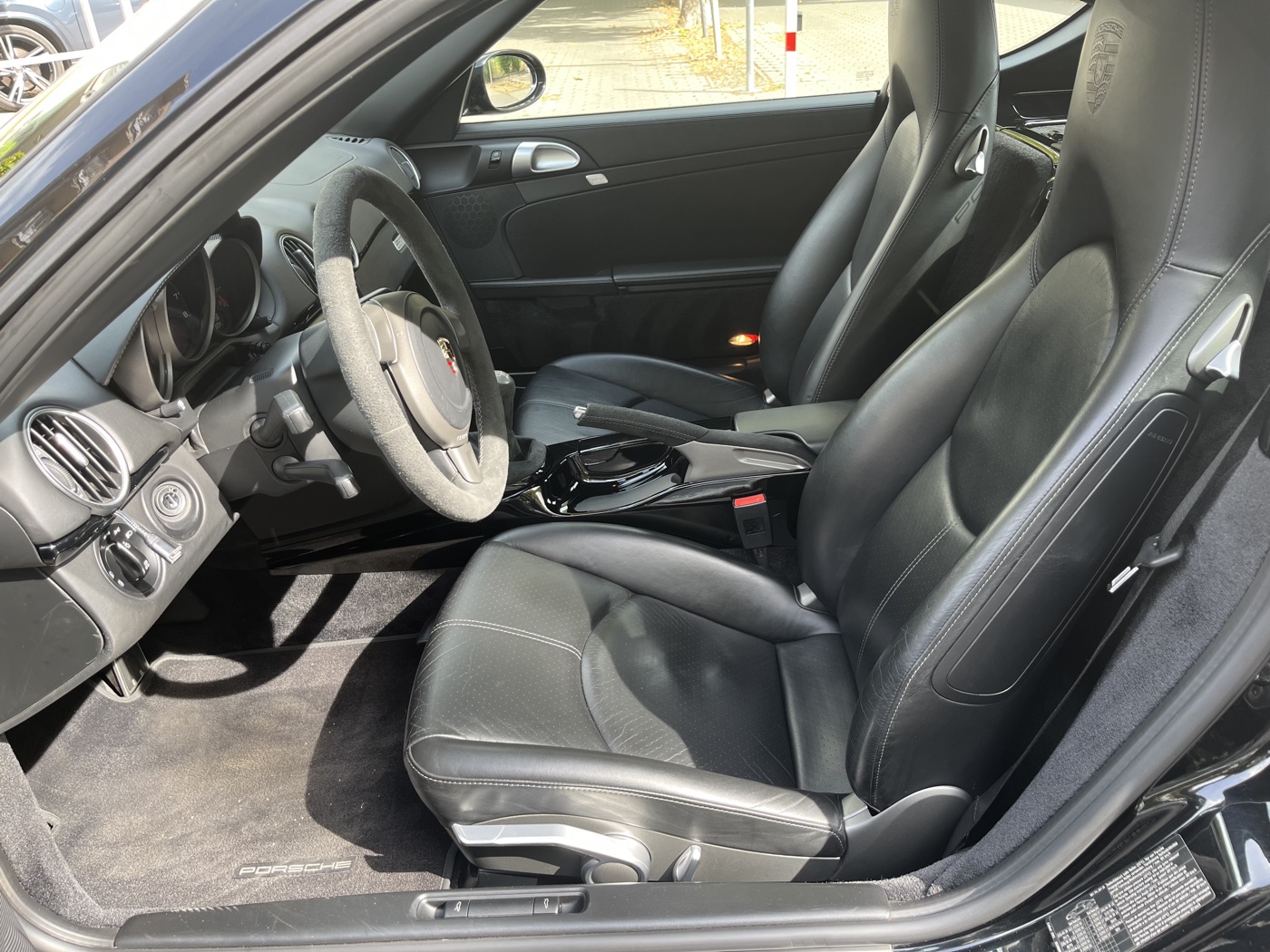 Fekete bőr sportülések fejtámlába nyomott Porsche címerrel